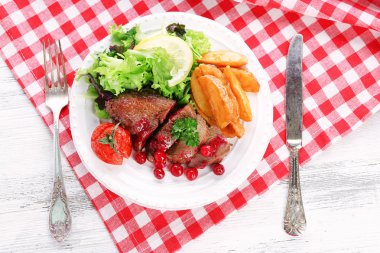 kızılcık sosu ve renk ahşap arka plan üzerinde plaka üzerinde kavrulmuş sebze ile lezzetli kavrulmuş et