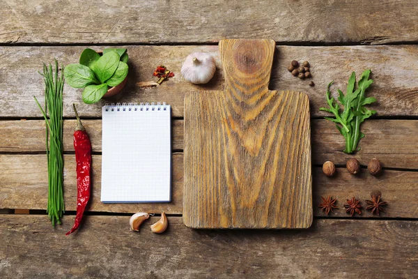 Open receptenboek met verse kruiden en specerijen op houten achtergrond — Stockfoto