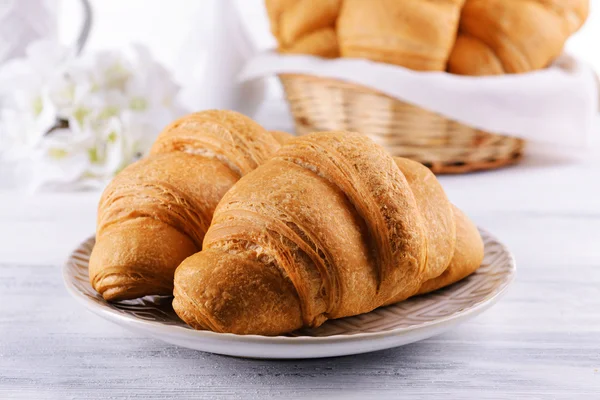 Läckra croissanter på tallriken på bordet närbild — Stockfoto