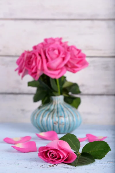 Schöne rosa Rosen in der Vase auf hölzernem Hintergrund — Stockfoto