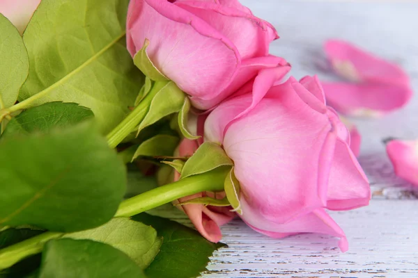 Schöne rosa Rosen auf Holztisch, Nahaufnahme — Stockfoto