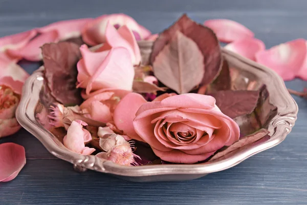 Hermosas rosas rosadas en placa de metal en la mesa de madera, primer plano —  Fotos de Stock