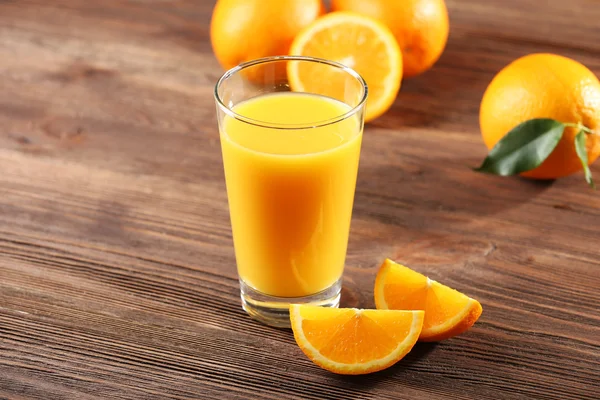 Orange juice on table on wooden background — Stock Photo, Image