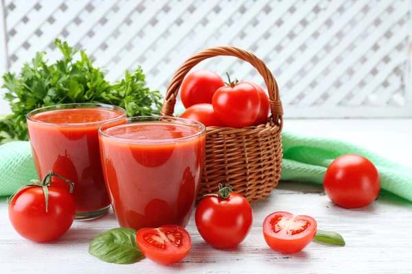 Glasögon av färsk tomatjuice på träbord, närbild — Stockfoto