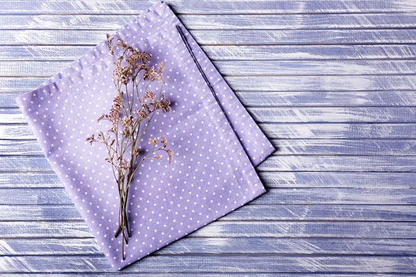 Belles fleurs sèches sur serviette sur fond en bois — Photo