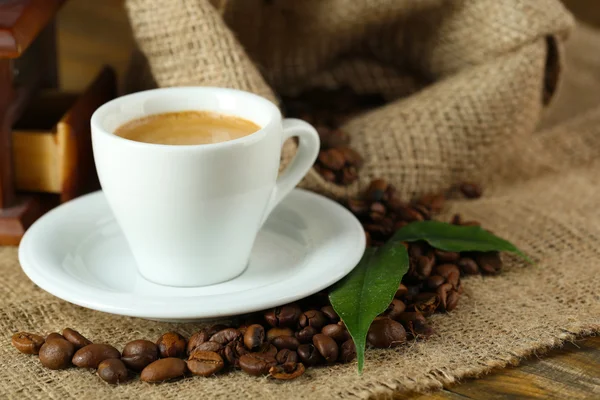 Tasse de café avec des grains sur la table fermer — Photo