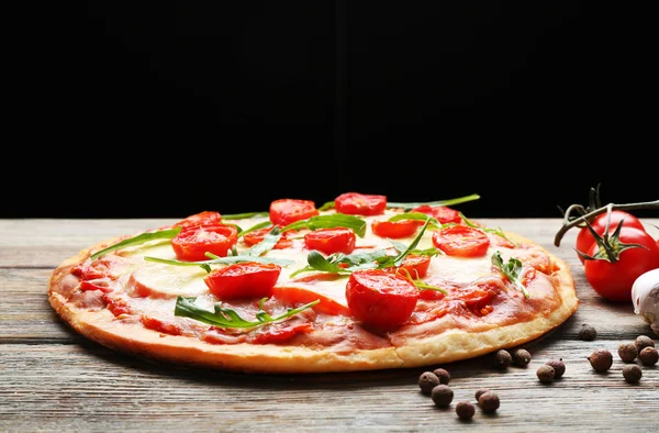 Peynirli ve kiraz domatesli lezzetli pizza. Ahşap masa üzerinde, arka planda. — Stok fotoğraf