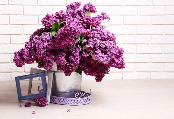 Beautiful lilac flowers in pail on floor in room close-up — Stock Photo, Image