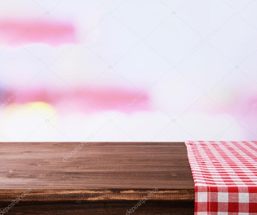 Empty wooden table with napkin on light background