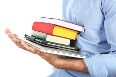 Dizüstü ve tablet üzerinde beyaz izole kitap yığını tutan adam