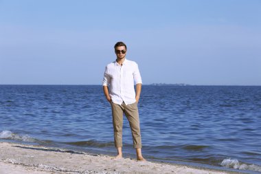 Kumsalda yürüyen genç adam