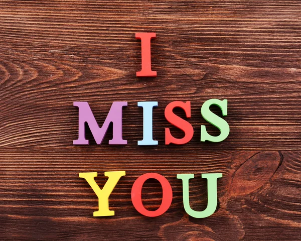 Iscrizione I MISS YOU fatta di lettere colorate su sfondo di legno — Foto Stock