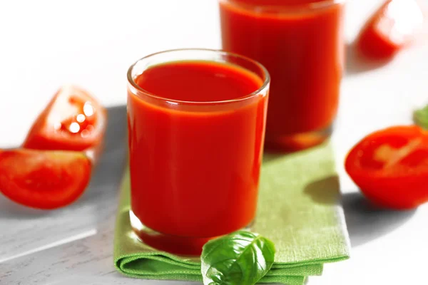 Jugo de tomate y tomates frescos en primer plano de mesa de madera — Foto de Stock