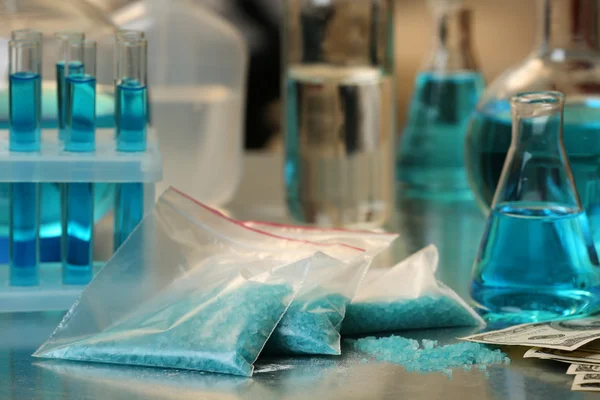 Drug laboratory: blue methamphetamine and money on table close up — Stock Photo, Image