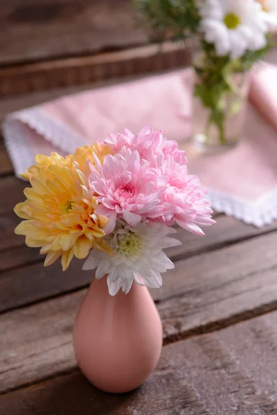 Beautiful flowers in vases on table close up — Stock Photo, Image