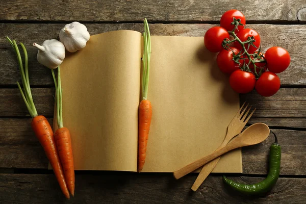 Livro de receitas aberto, legumes e especiarias — Fotografia de Stock