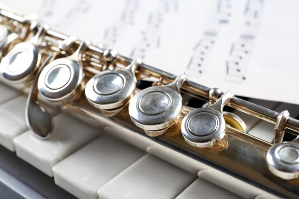 Flauta e piano com folha de música de perto — Fotografia de Stock