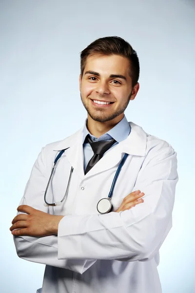 Mavi arka plan üzerinde stetoskop ile erkek doktor — Stok fotoğraf