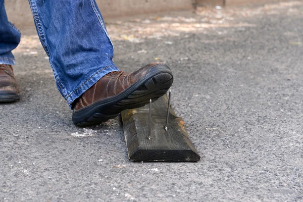 Worker steps on nail outdoors — Stock Photo, Image