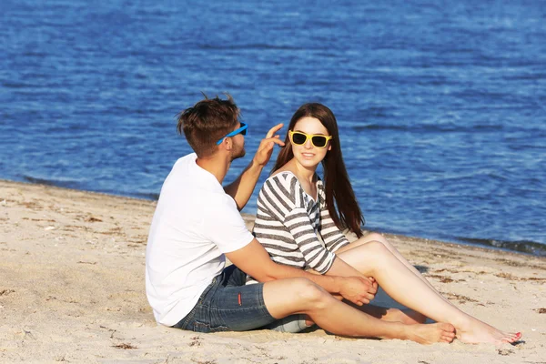 Молода пара сидить на пляжі — стокове фото
