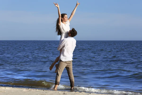 Jeune couple étreignant sur la plage — Photo