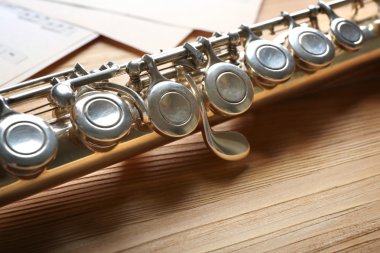 Ahşap masa üzerine müzik notlar ile gümüş flüt yakın çekim