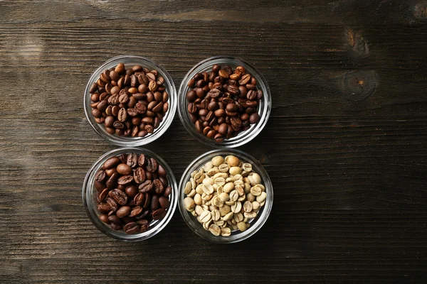 Coffee beans in saucers on wooden background — Stock Photo, Image