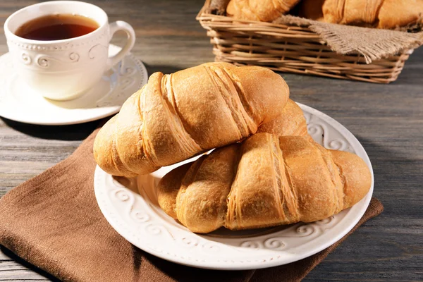 Deliciosos croissants en el plato en primer plano de la mesa —  Fotos de Stock