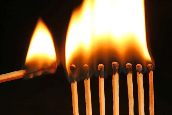 Burning matches on black background — Stock Photo, Image