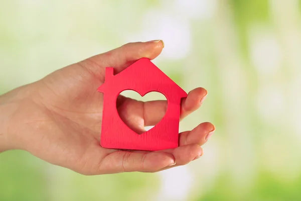 Female hand with model of house on blurred background — Stock Photo, Image