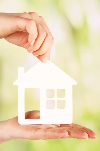 Female hands with model of house on blurred background — Stock Photo, Image