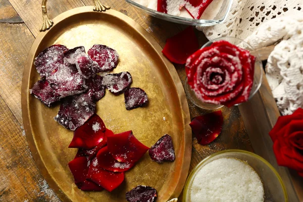 Fare petali di fiori di rosa canditi con albumi e zucchero, su sfondo di legno — Foto Stock