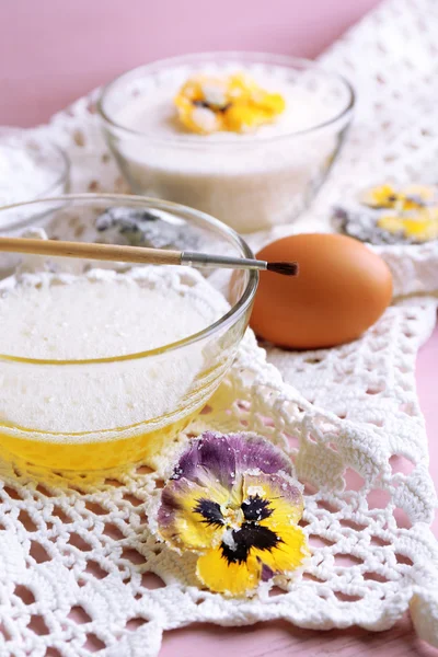 Elaboración de flores violetas confitadas con claras de huevo y azúcar, sobre fondo de madera de color —  Fotos de Stock