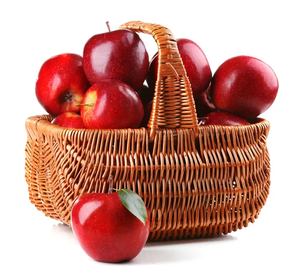 Röda äpplen i rotting korg isolera på vit — Stockfoto