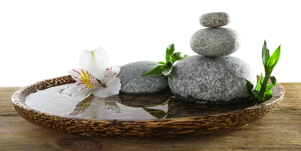 Spa stones with alstroemeria and bamboo in wooden tray with water isolated on white — Stock Photo, Image