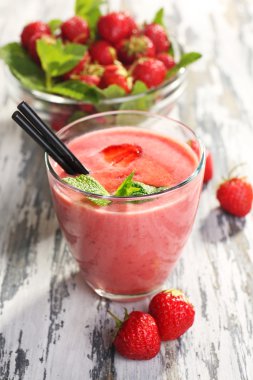 milkshake with strawberries on table