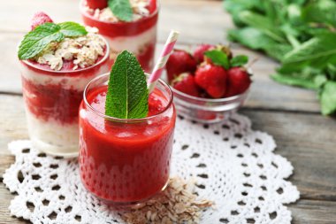 Strawberry smoothie and deserts on wooden table background