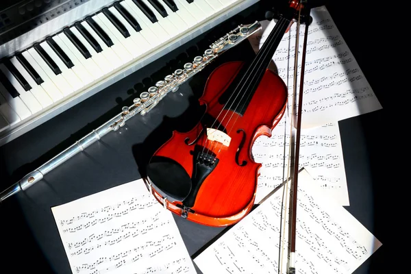 Instrumentos musicales con notas musicales sobre fondo oscuro — Foto de Stock