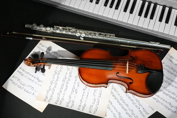 Instrumentos musicales con notas musicales sobre fondo oscuro —  Fotos de Stock