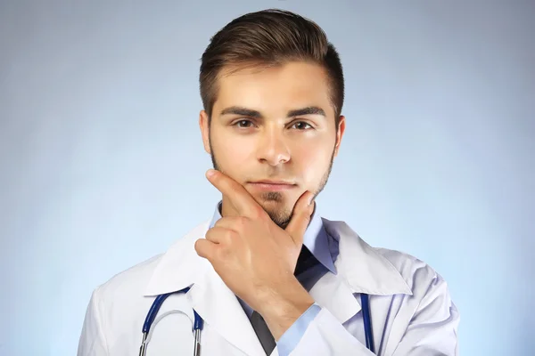 青の背景に聴診器で男性医師 — ストック写真