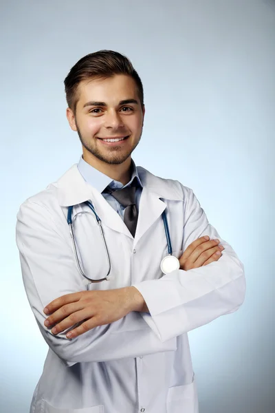 Médico masculino com estetoscópio em fundo azul — Fotografia de Stock