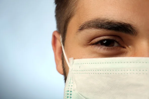 Joven médico masculino sobre fondo azul — Foto de Stock