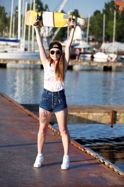 Piękna dziewczyna tatuażem z deskorolka, na zewnątrz — Zdjęcie stockowe