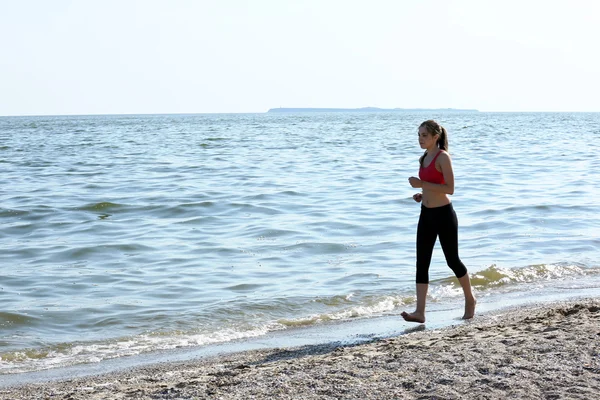 Young woman jogging on beach — Stock Photo, Image