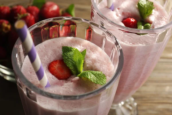 Milkshake with strawberries on table — Stok fotoğraf