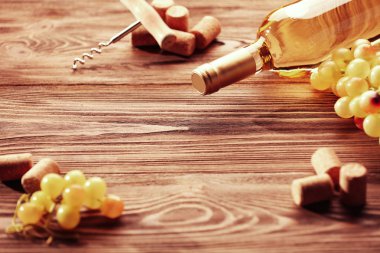 Wine bottle with corks, corkscrew and grapes
