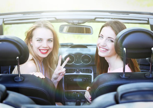 Две девушки в кабриолете, на улице — стоковое фото