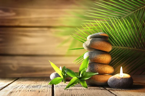 Spa stones, candle on wooden background — Stockfoto