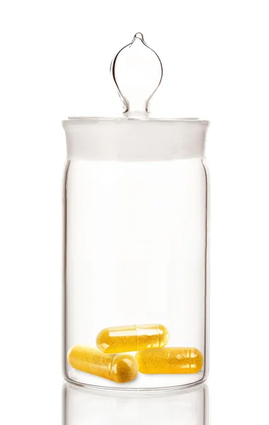 Vaso trasparente con pillole isolate su bianco — Foto Stock