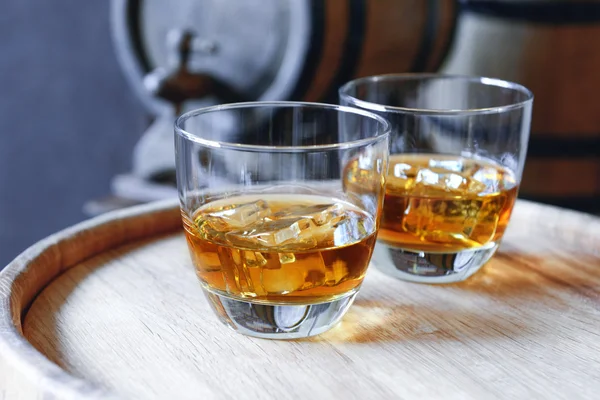 Glazen voor brandy in kelder met oude vaten — Stockfoto